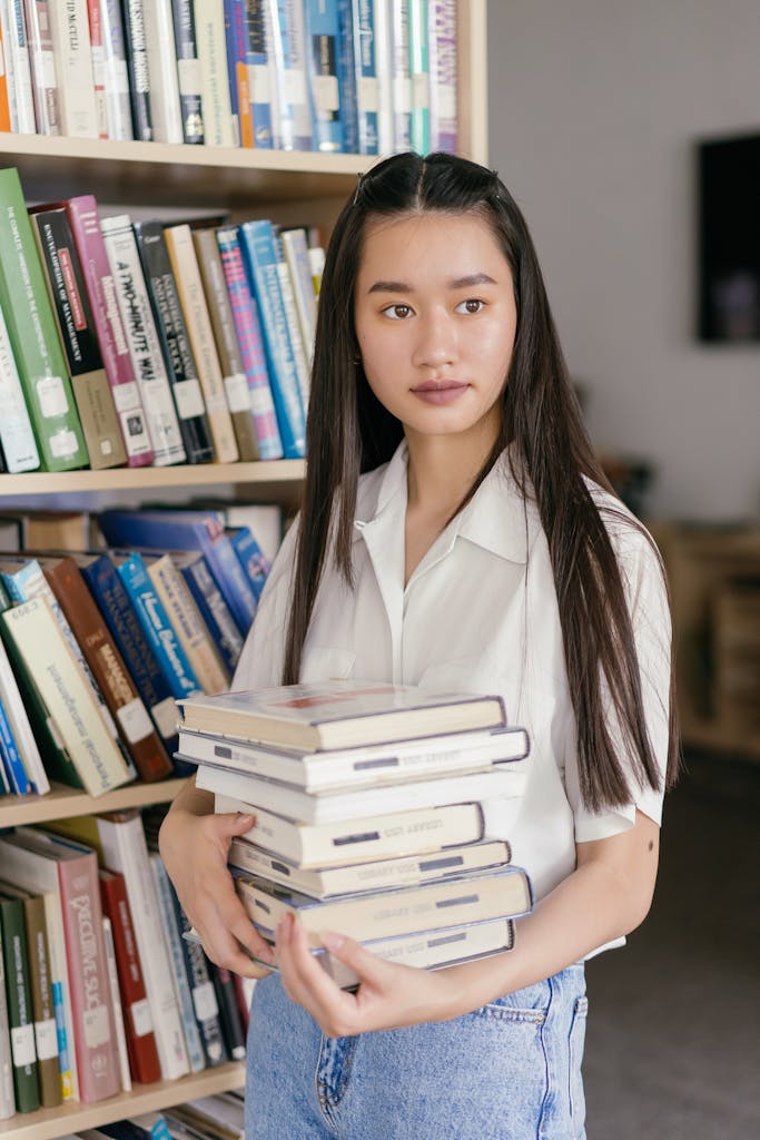 Woman in White Button Up Shirt Holding Books